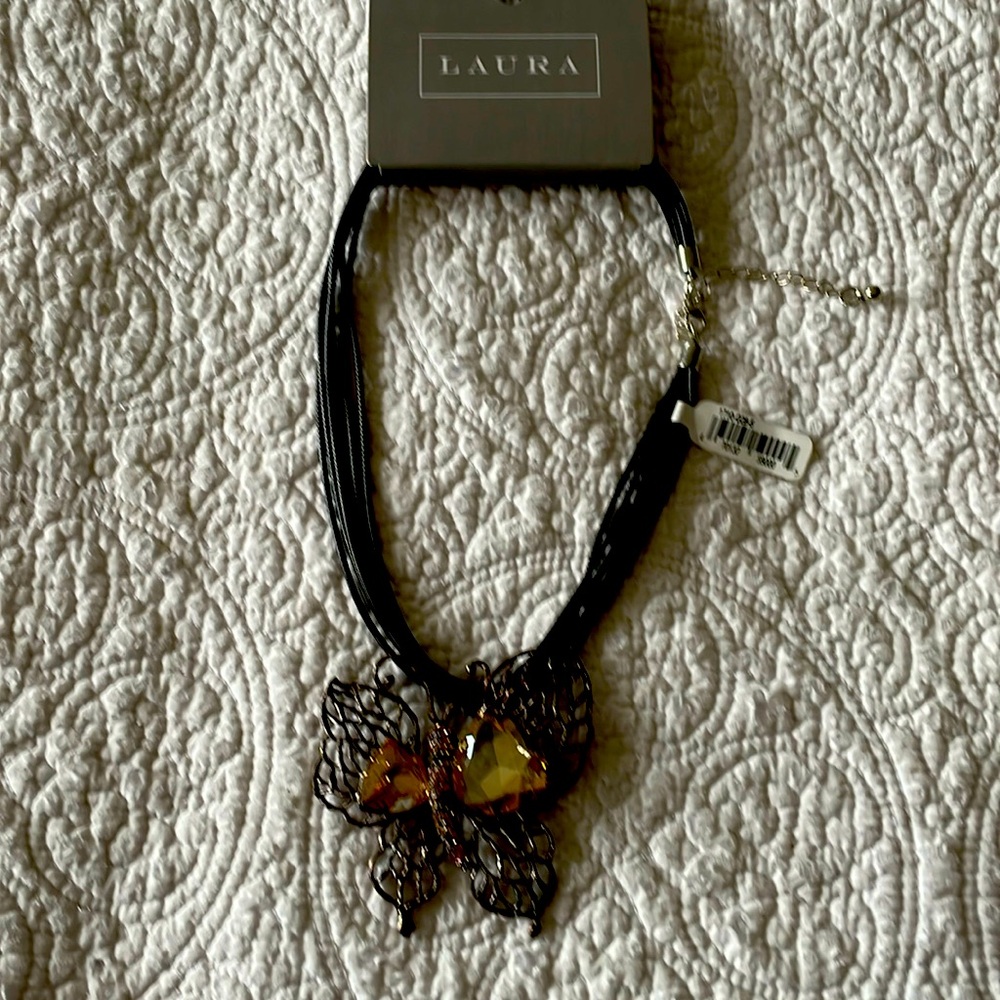Butterfly necklace with yellow and pink stones.